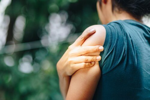 腱損傷の原因は何ですか? 肩が痛い女性