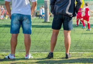 親が子供のスポーツに与える影響とは? サッカーの試合を観戦する保護者