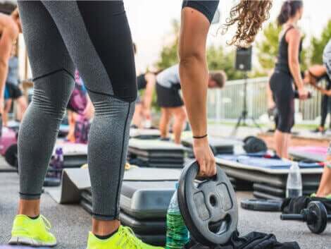 人気のワークアウトプログラムBODYPUMPについて学ぼう! プレートを手に取る女性